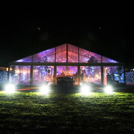 Night time lighting inside and outside a completely clear marquee creates a dramatic spectacle