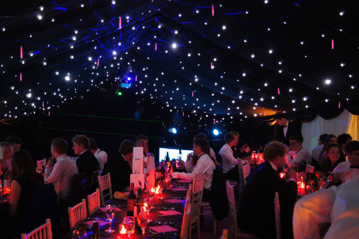 Party dining in a blacked out marquee with twinkly starlight ceiling