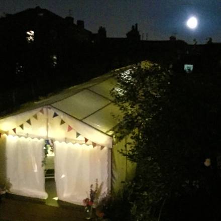 Garden marquee at night with the moon overhead