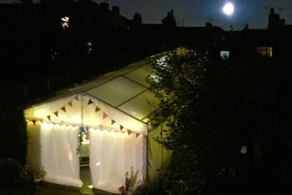 Garden marquee at night with the moon overhead