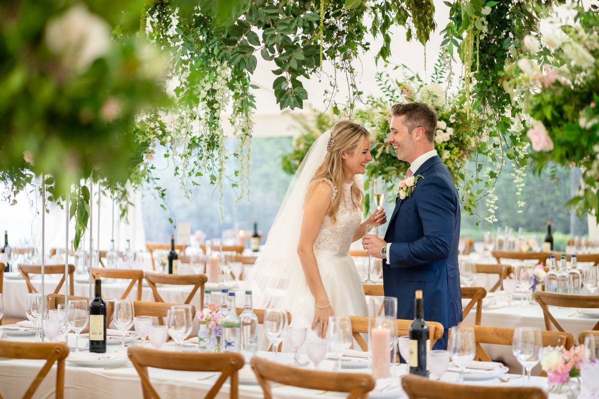 Bride and groom in flowery marquee