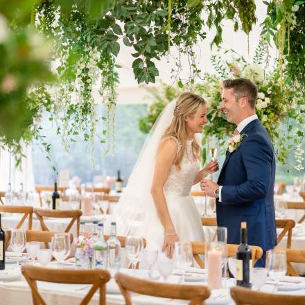 Bride and groom in flowery marquee