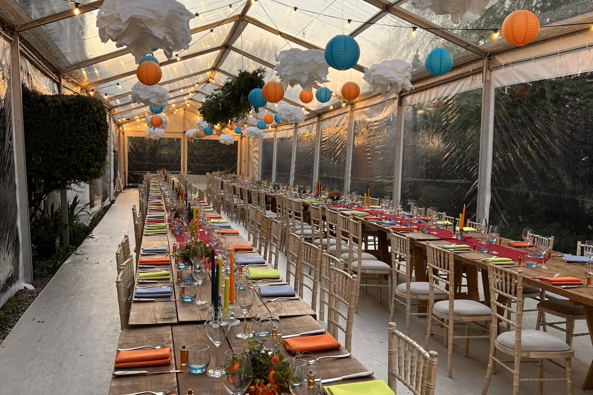 Relaxed, colourful table decoration with stained wood vintage trestle tables