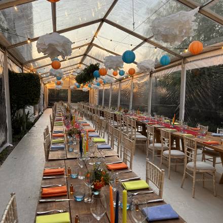 Relaxed, colourful table decoration with stained wood vintage trestle tables