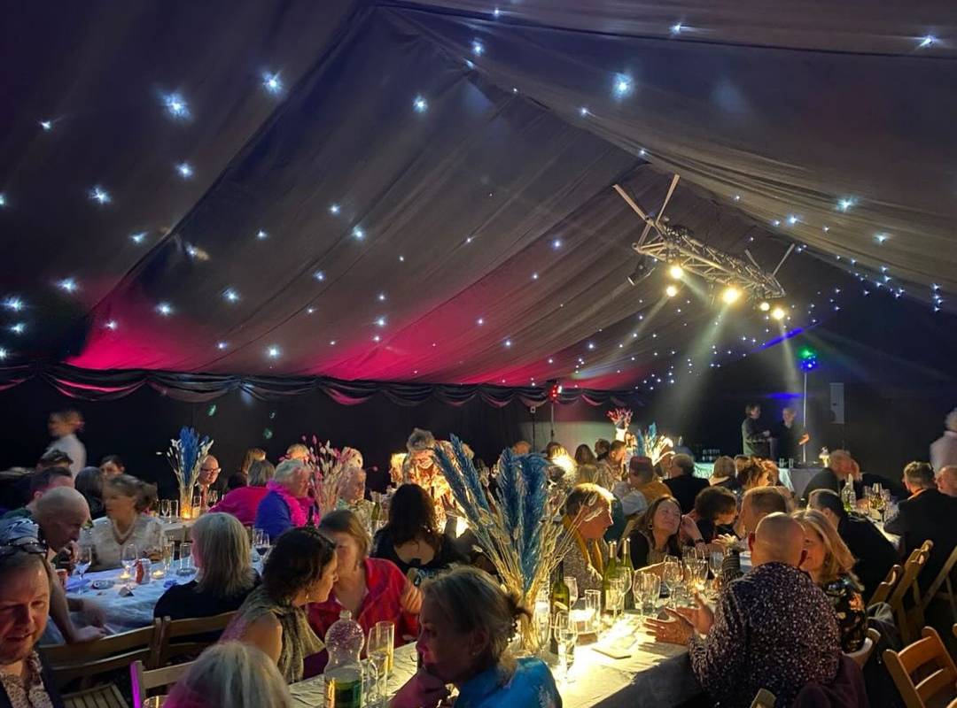 Party in blacked out marquee with night sky