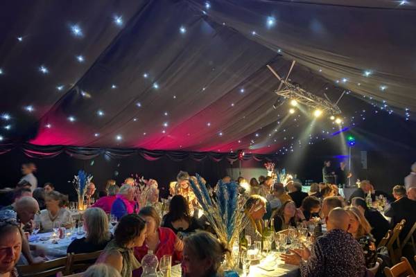 Party in blacked out marquee with night sky