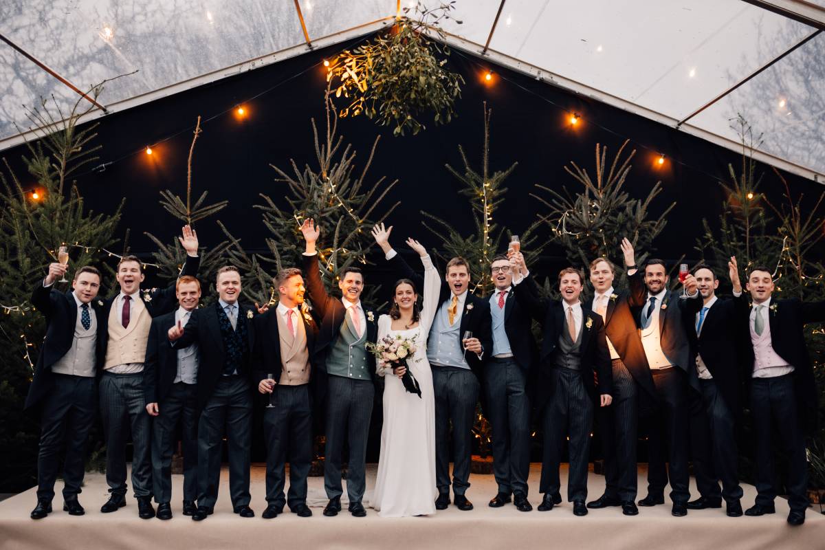 Bride and all the boys in front of Christmas trees
