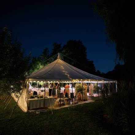 Traditional marquee in a garden lit up at night