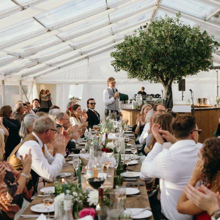 Applauding a speech inside a clear wedding marquee