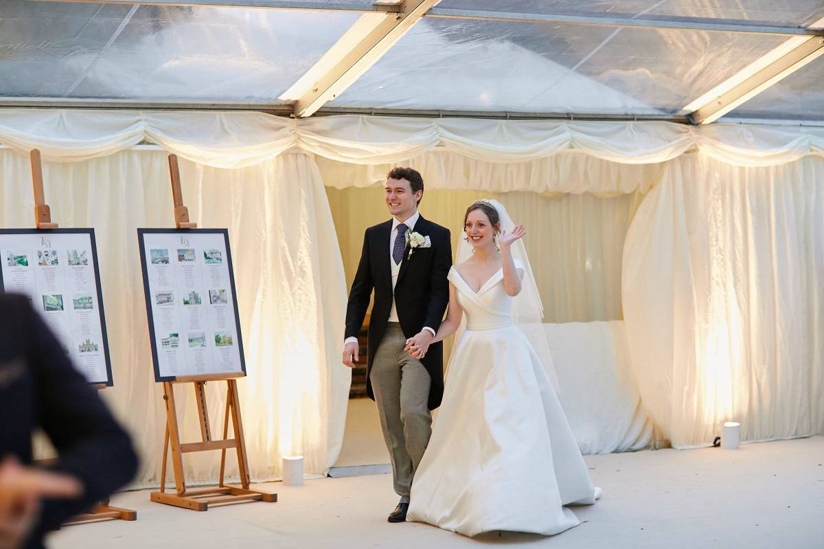 Bride and groom make their entrance into the marquee