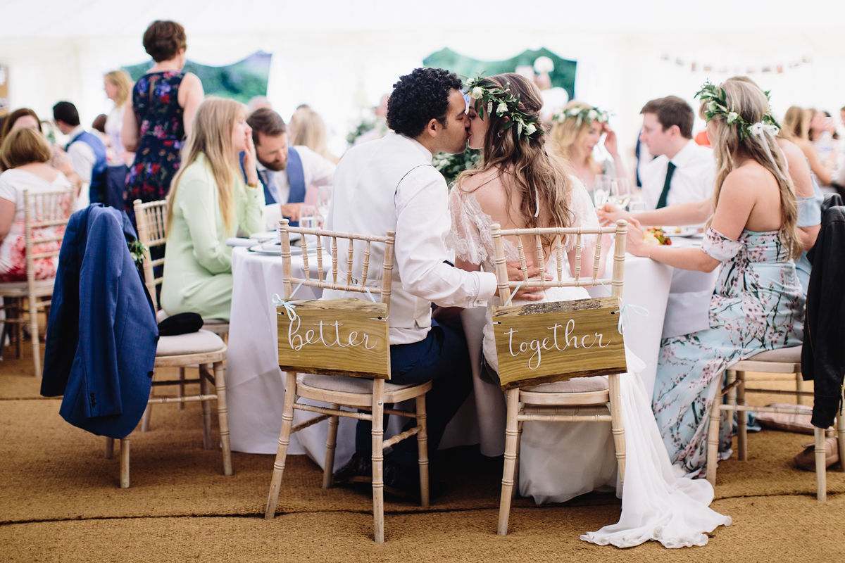Bride and groom kiss in their wedding marquee