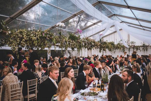 Dining under a clear roof with greenery