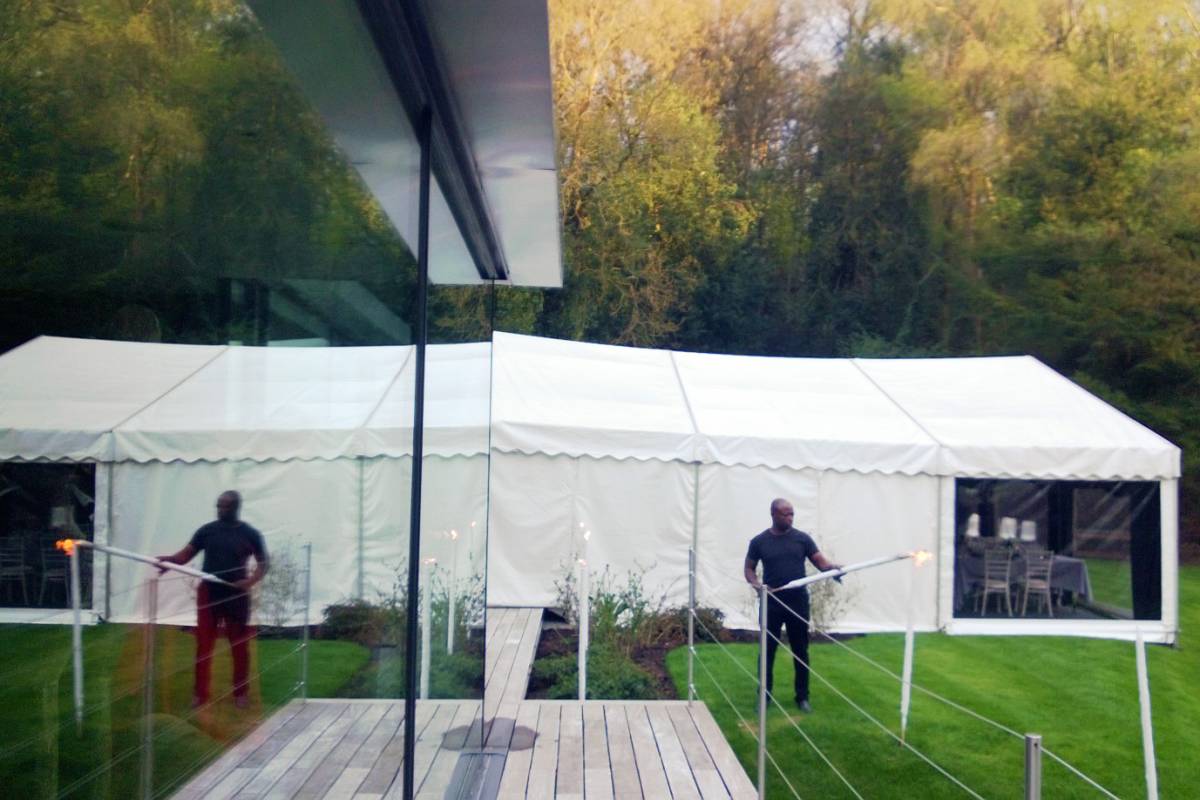 Marquee reflected in a glass walls of a glass house