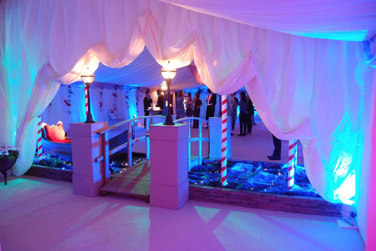 Entrance to Venice themed marquee with a bridge over a bubble wrap river with a gondola