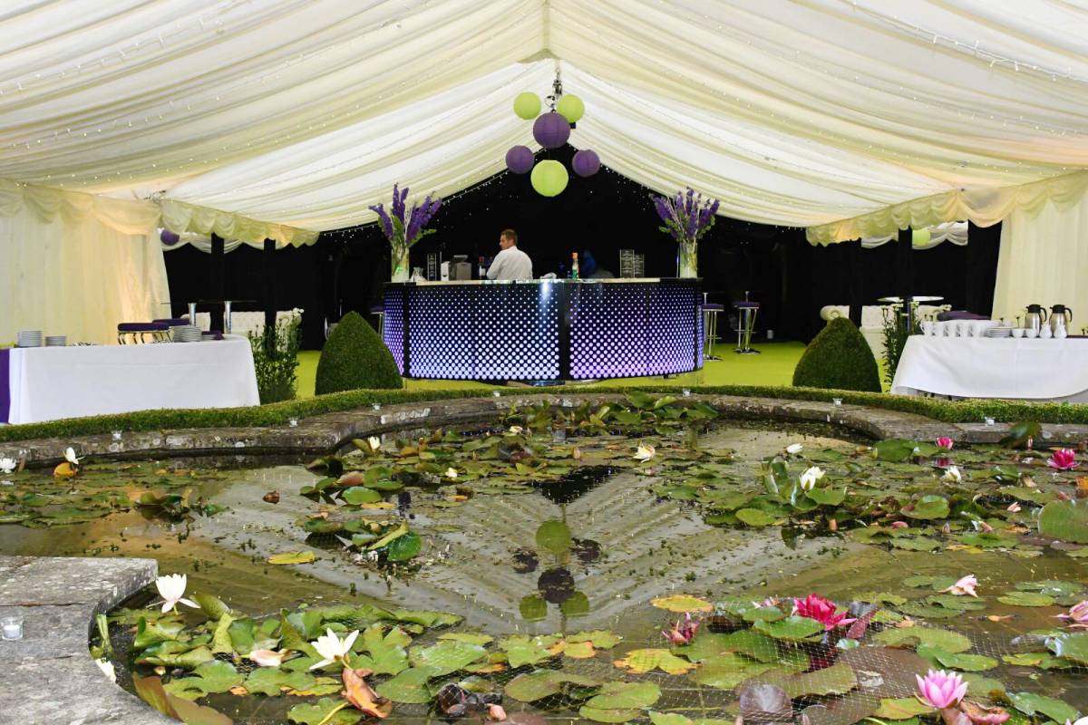 Marquee spanning a large garden pond