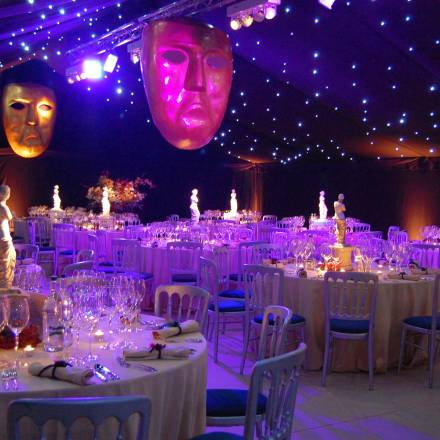 Glittering Venice themed dining marquee with huge hanging carnival masks