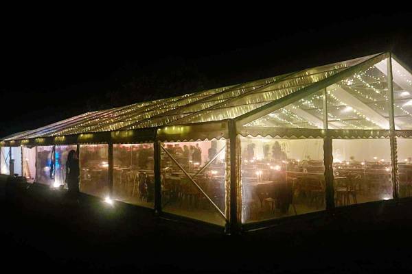 Interior of a completely clear marquee with a fairy light canopy