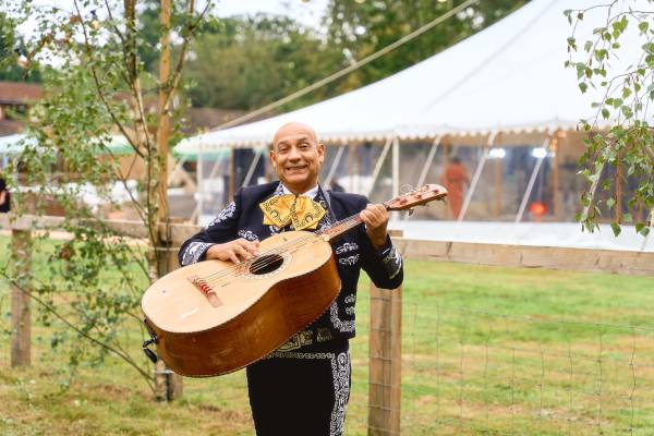 Mexican musician playing guitar outside marquee