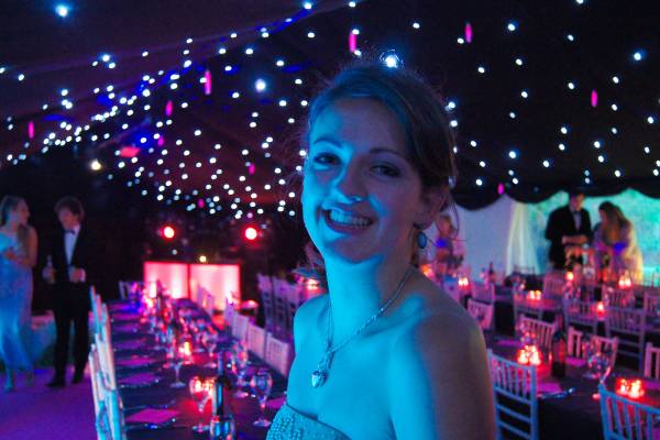 Birthday girl in a blacked out, vibrantly lit marquee for her eighteenth