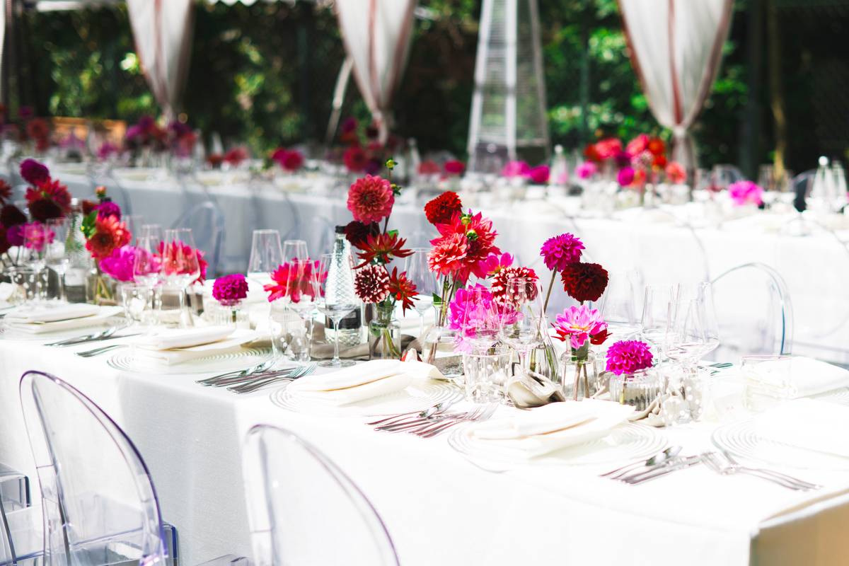Bright pink flowers pop against plain white table dressing