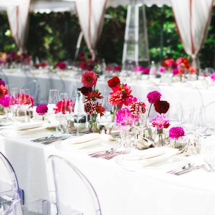 Bright pink flowers pop against plain white table dressing