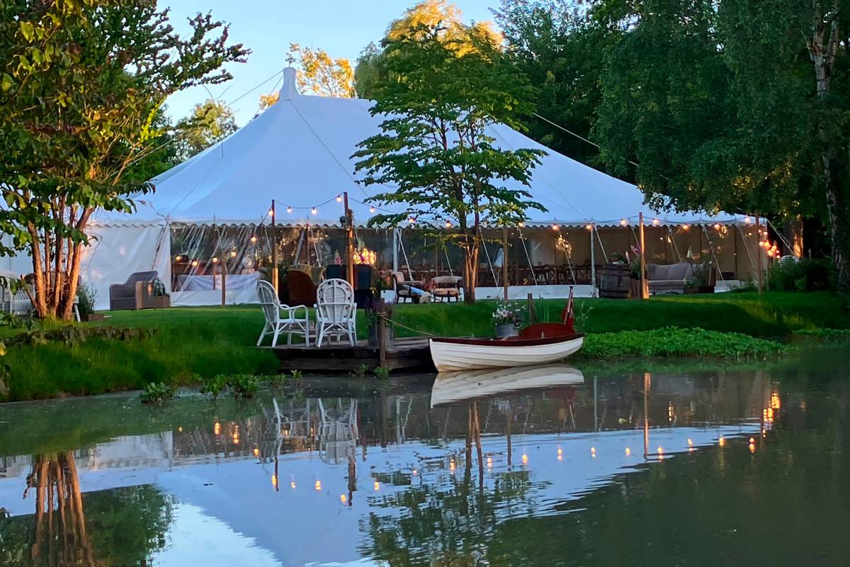 Traditional tent at dusk with lakeside reflections