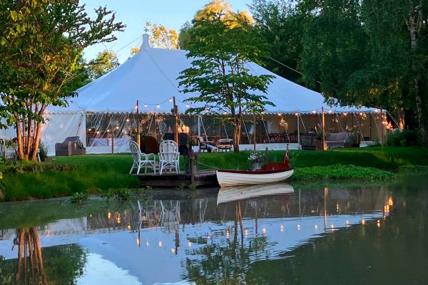 Traditional tent at dusk with lakeside reflections