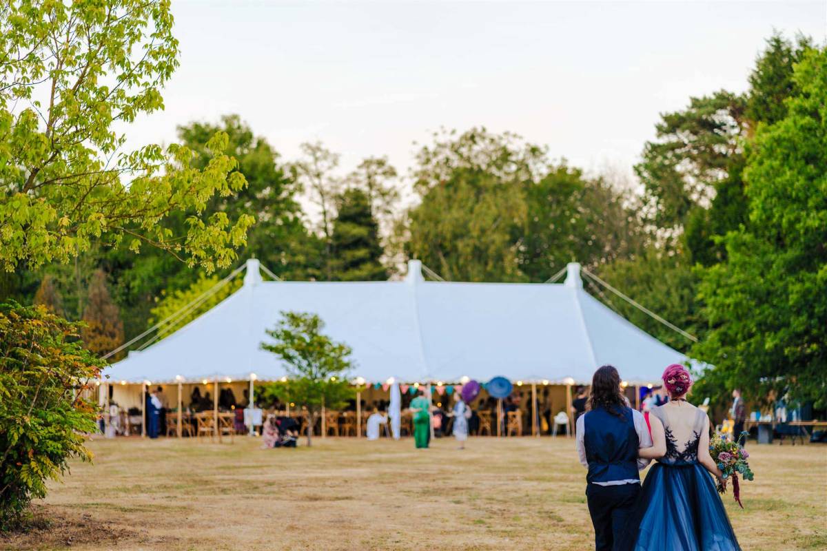 Bride and groom survey their traditional style marquee