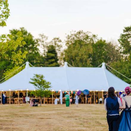 Bride and groom survey their traditional style marquee