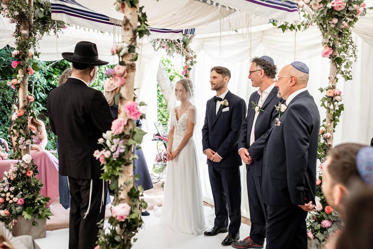 Under a prettily decorated Jewish wedding canopy