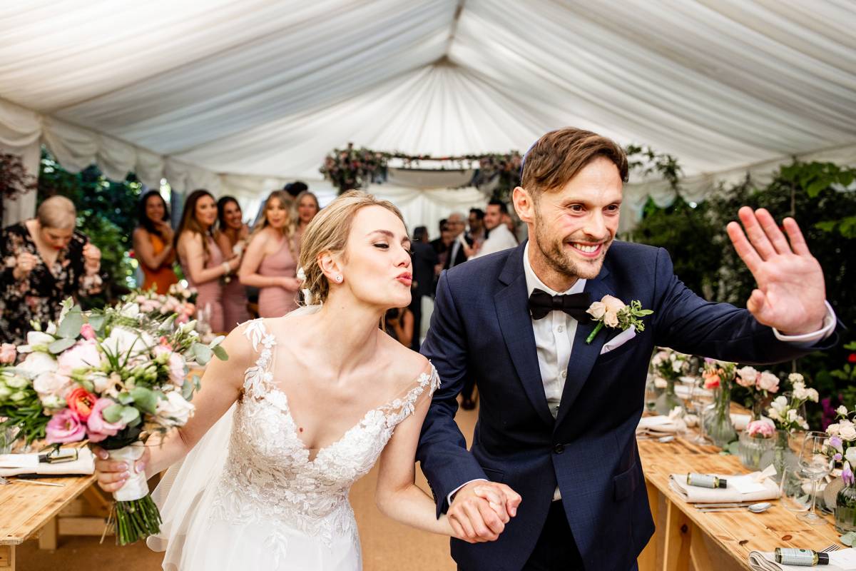 Bride and groom triumphantly marqueed