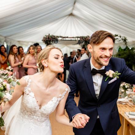 Bride and groom triumphantly marqueed