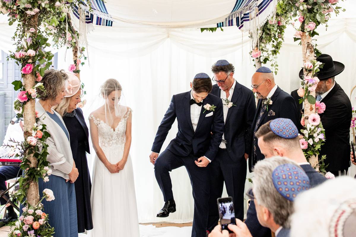 Groom stamping on glass as per Jewish tradition