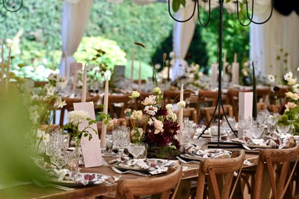 Dressed vintage trestle tables with flowers and candles in light earthy tones